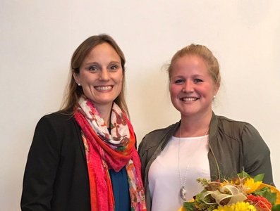 Foto mit Frau Dr. Tanja Naegele und Frau Pia Igel die einen Blumenstrauß in der Hand haelt